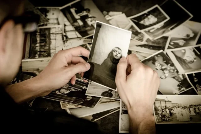Hands sorting through printed personal photographs
