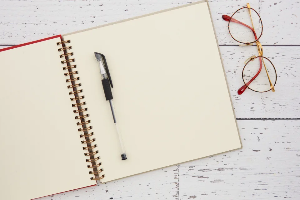 Open notebook next to a laptop on a desk, ready for learning
