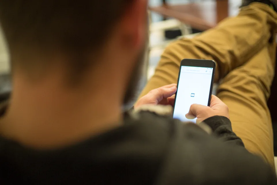 Person browsing an app store on a smartphone before downloading an app